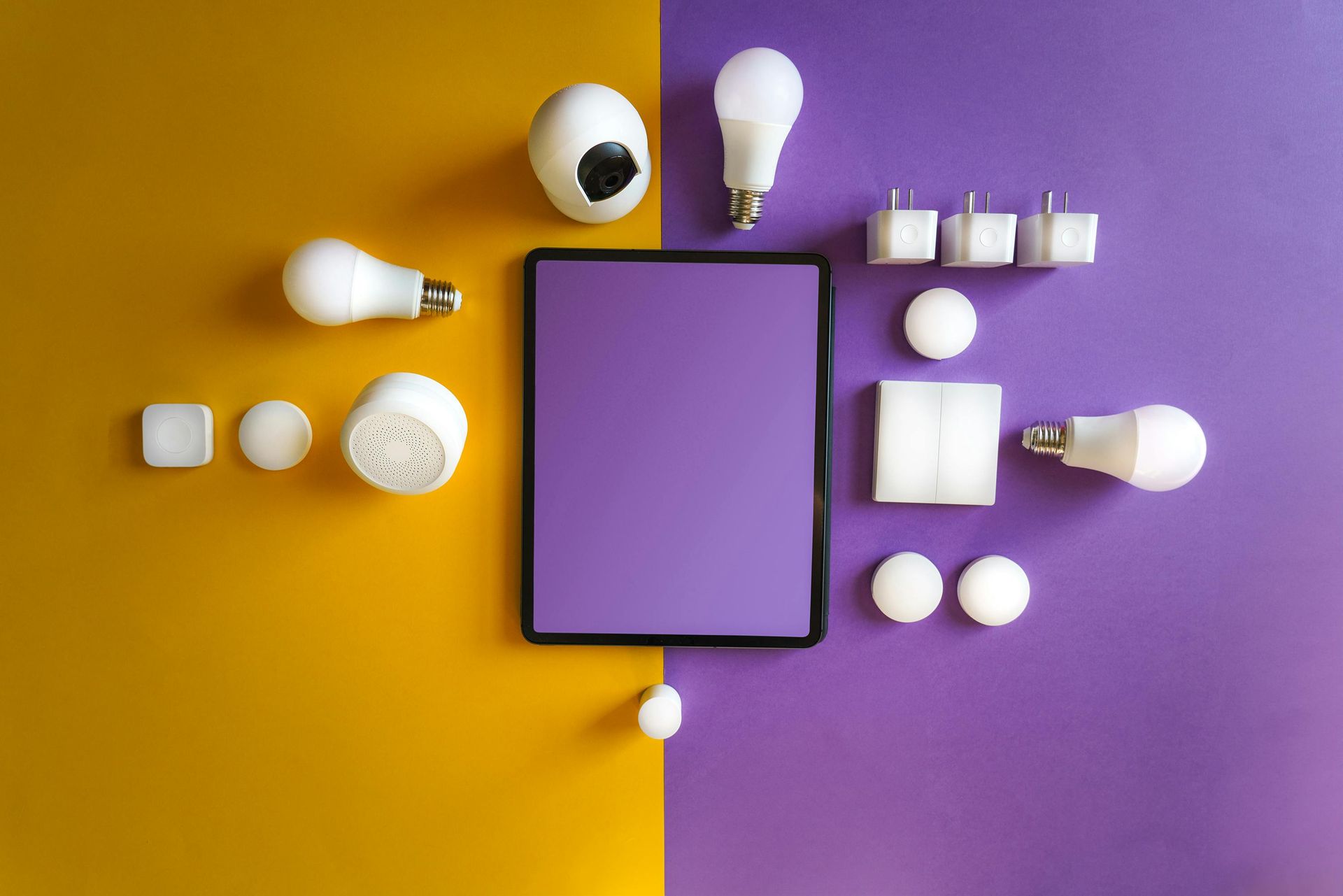 Yellow and purple background with white lightbulbs and plugs surrounding a purple tablet.