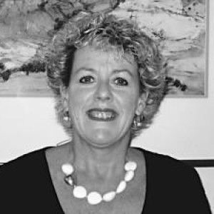 A Woman Wearing a Necklace and Earrings Is Smiling in A Black and White Photo — Linda Emery & Associates In Gosford, NSW