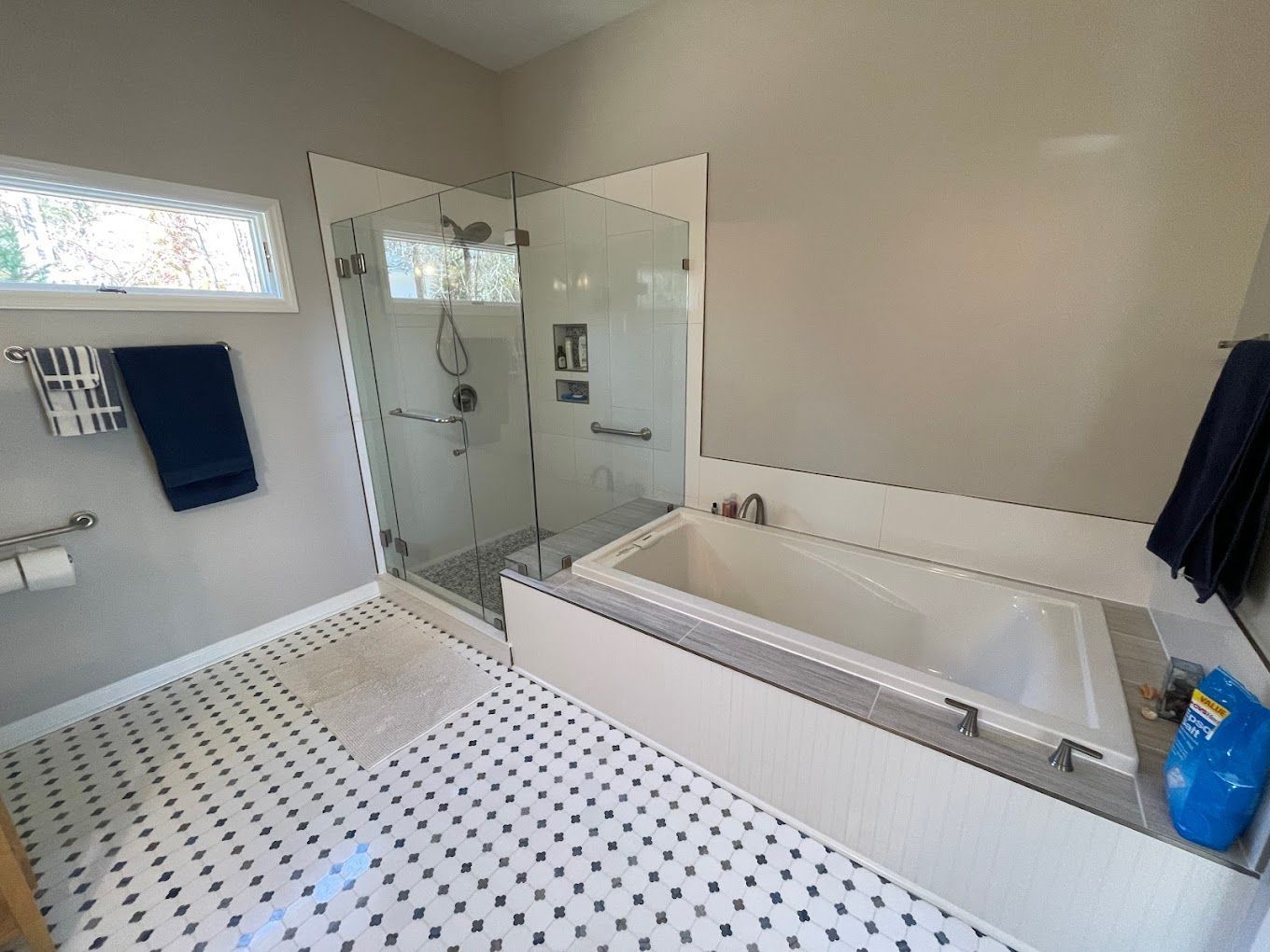A bathroom with a tub , shower , and mirror.