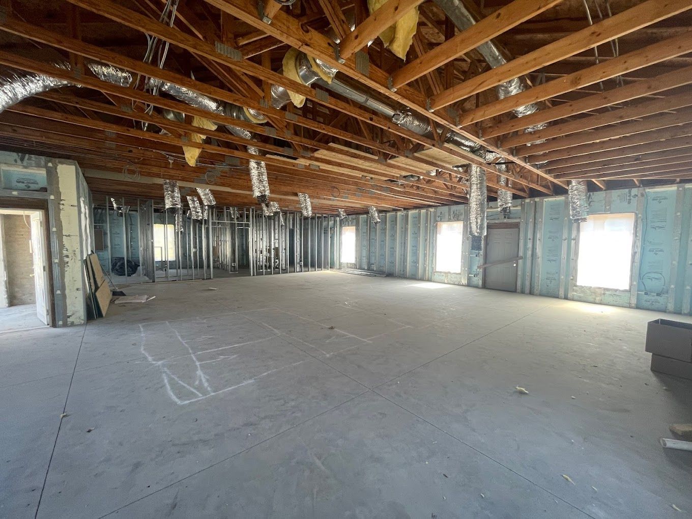 A large empty room with a wooden ceiling and a lot of windows.