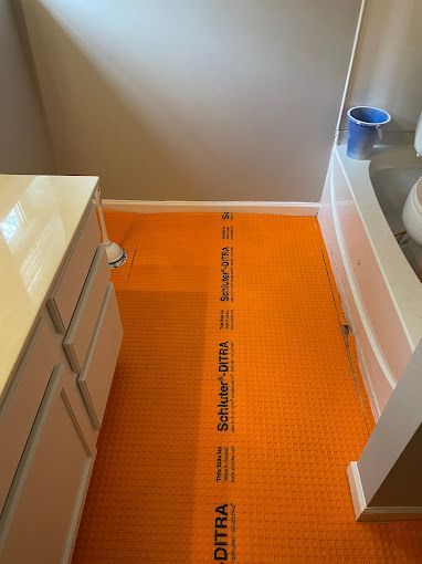 A bathroom with an orange floor and a bathtub.