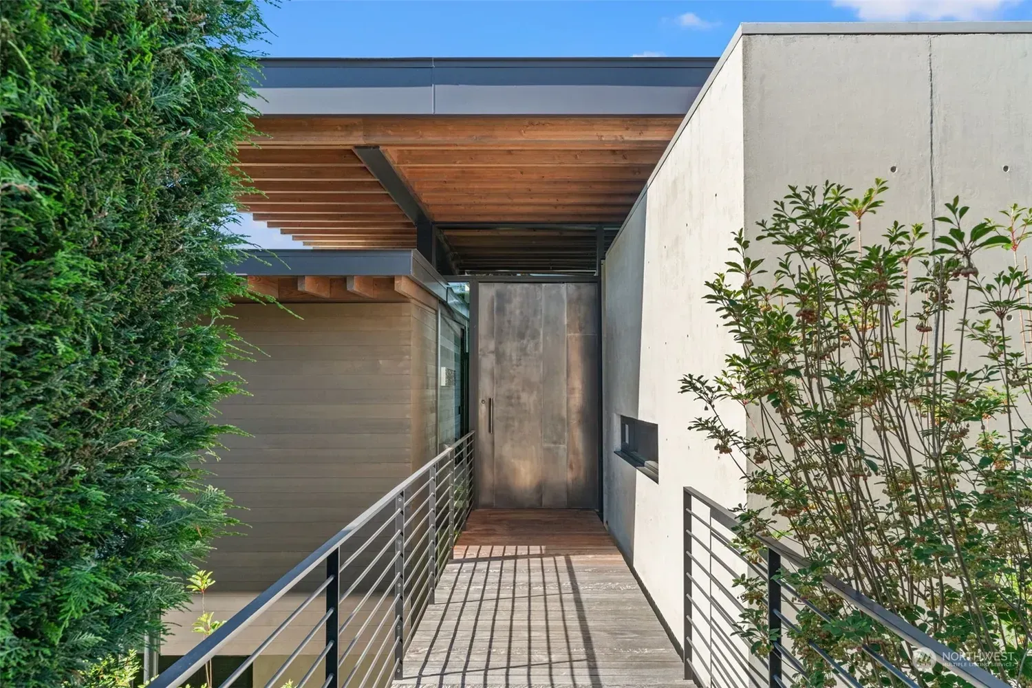 A modern house with a brick walkway leading to the front door.