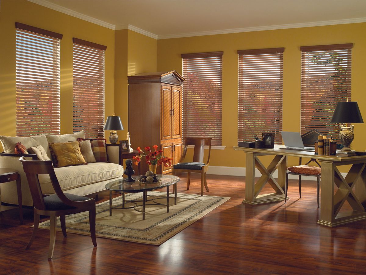 Living room with wood blinds, furniture, rug, and yellow walls.