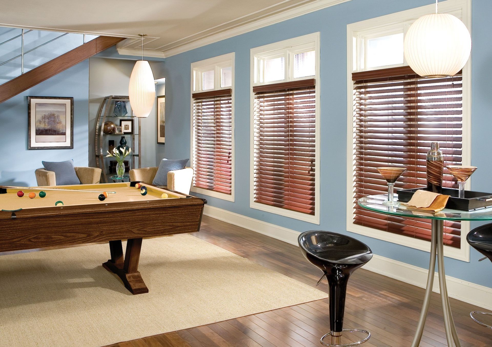 Pool room with pool table, bar table, wooden blinds, blue walls, and light fixtures.