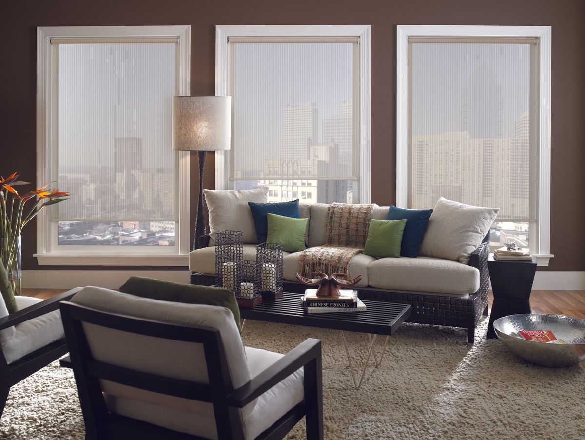 Living room with sofa, chairs, windows with blinds, and decorative accents.