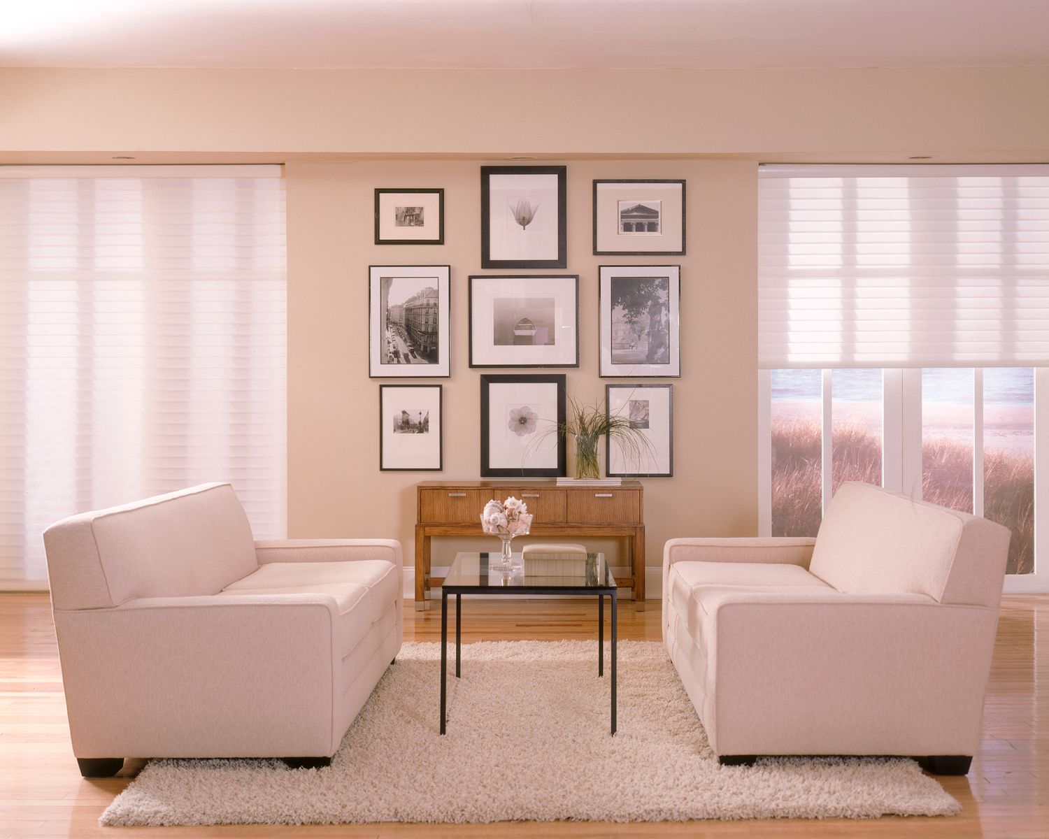 Living room with two cream sofas, gallery wall, small table, and rug.