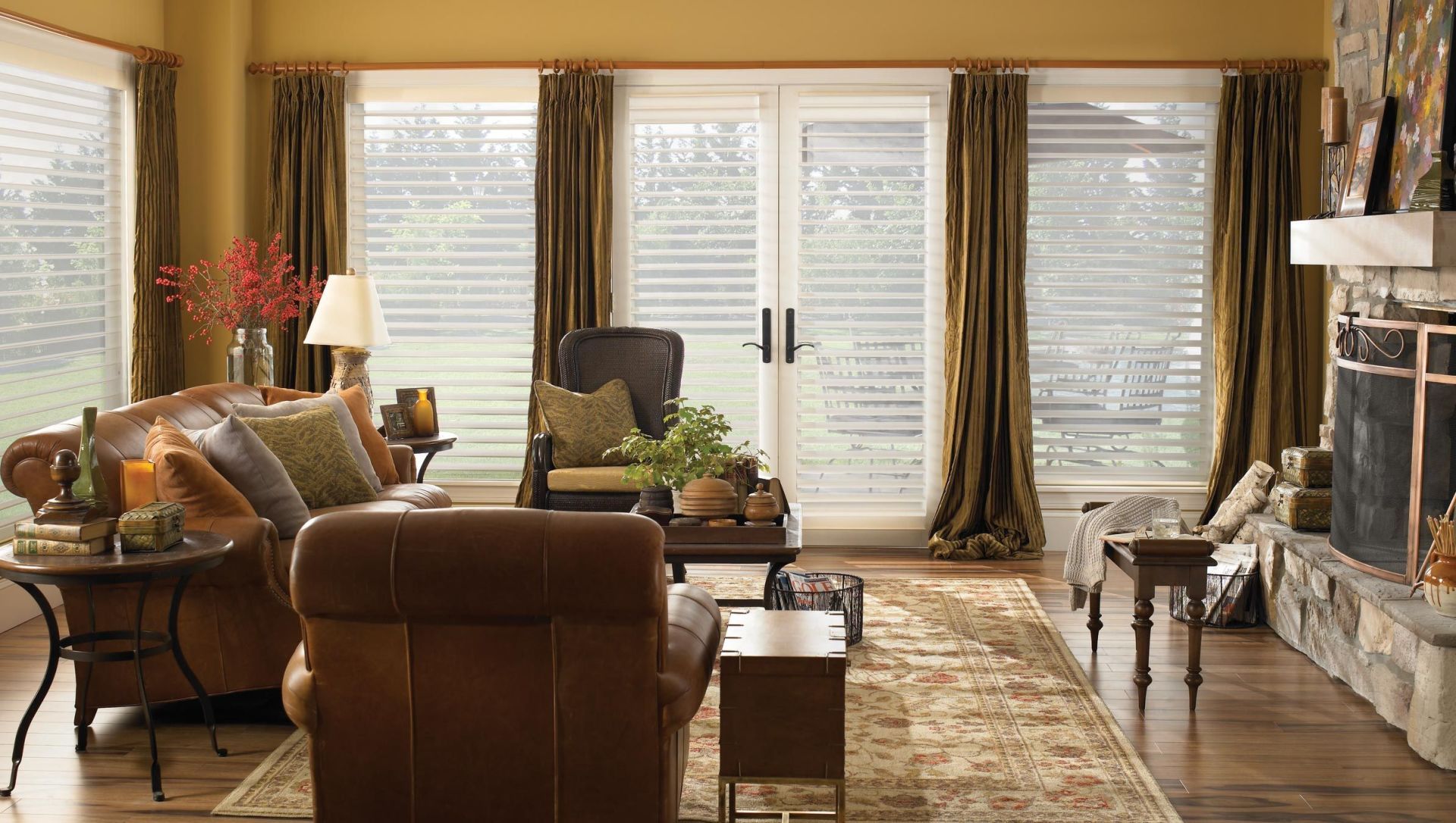 Living room with brown leather furniture, fireplace, and window with curtains.