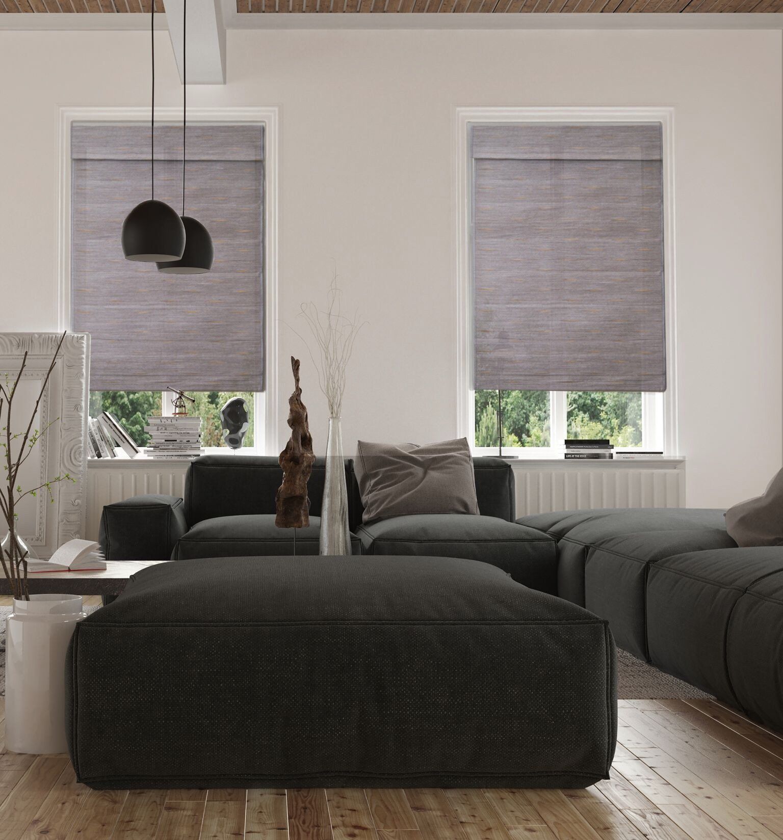 Living room with gray blinds, black sectional, ottoman, and decor.