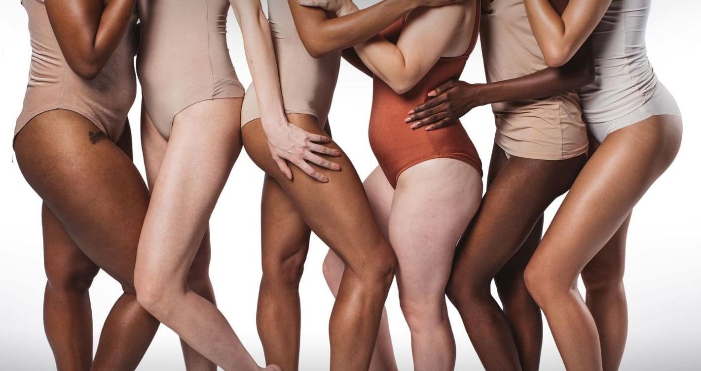 A group of women of different races are standing next to each other.