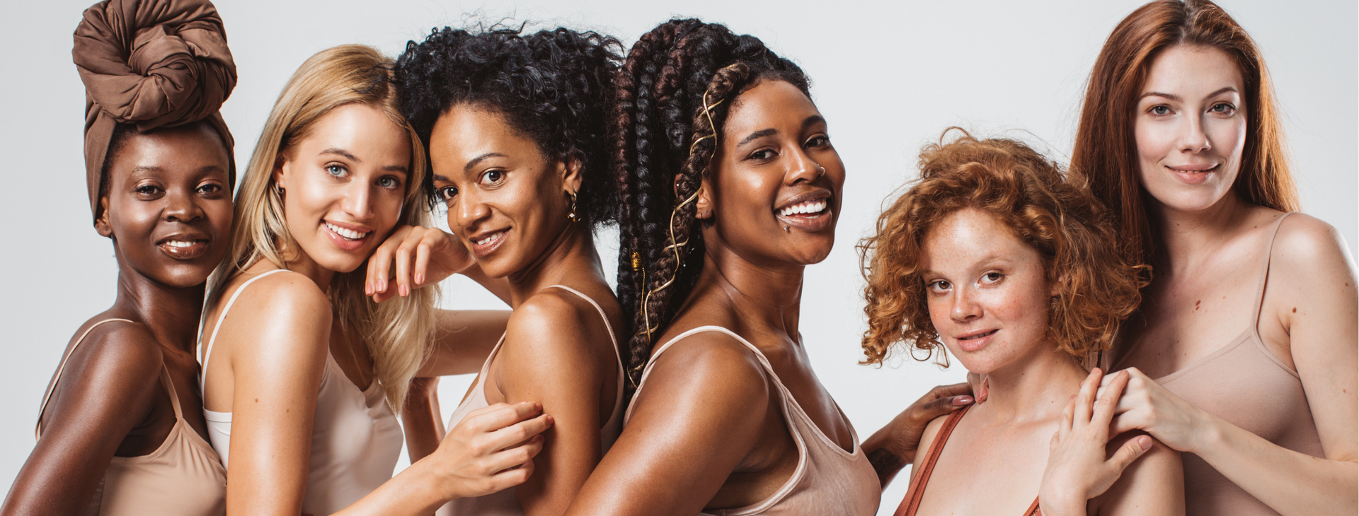 A group of women of different races are posing for a picture together.