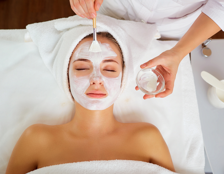 A woman is getting a facial treatment at a spa.