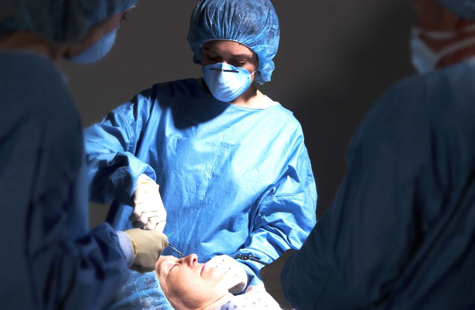 a group of surgeons are performing surgery on a patient