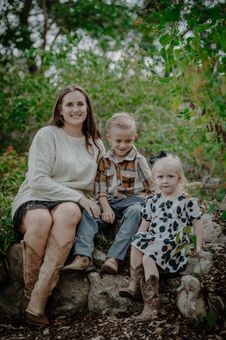 A woman and her 2 children posing for a picture. 