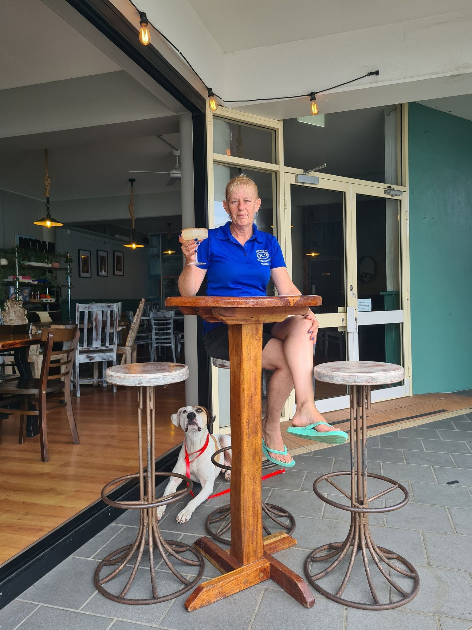 Woman Sitting at a Table Outside a Cafe — Amanda's Professional K9 Training In Forster, NSW