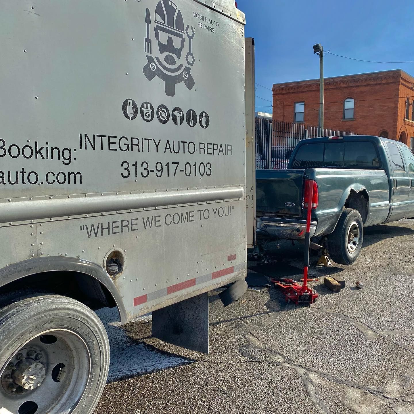 A truck that says integrity auto repair is parked next to another truck