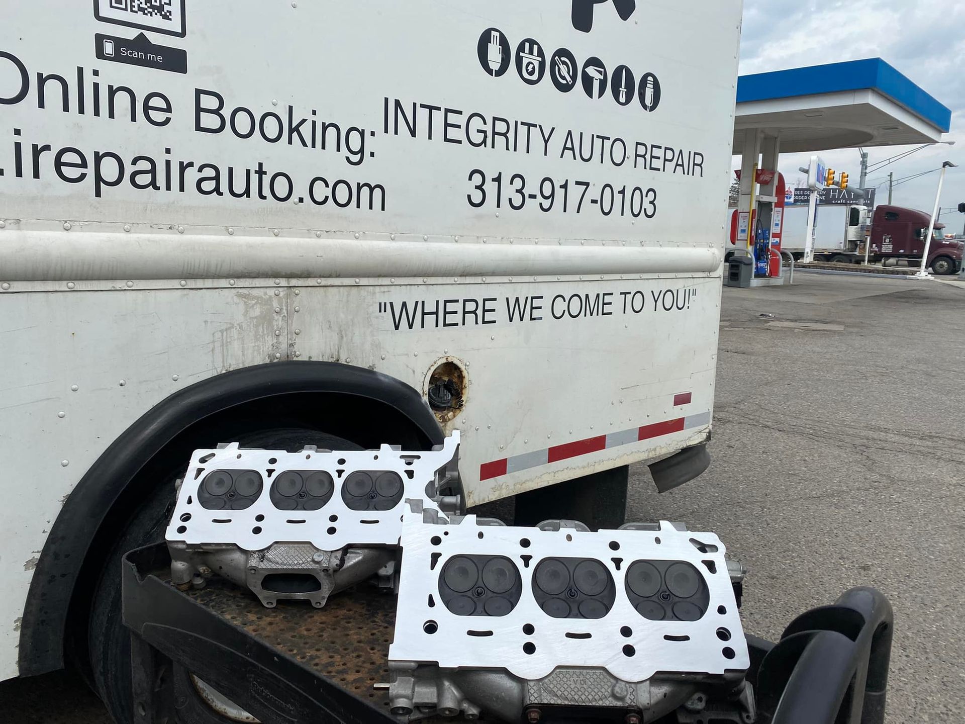 A white truck that says online booking integrity auto repair