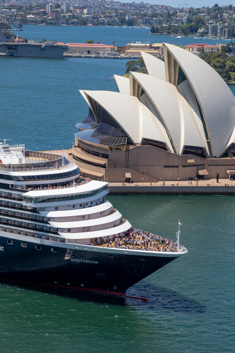Cruise ship in Sydney Harbour, passing the Sydney Opera House on a sunny day.