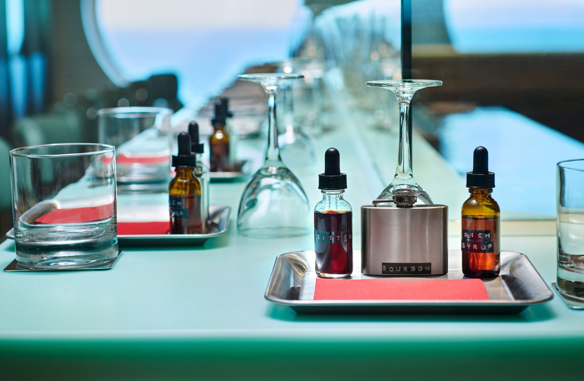 Cocktail ingredients and tools on a counter, with glasses and bottles arranged at The Test Kitchen - Virgin Voyages Experimental, chef-led tasting lab serving inventive, multi-course dishes