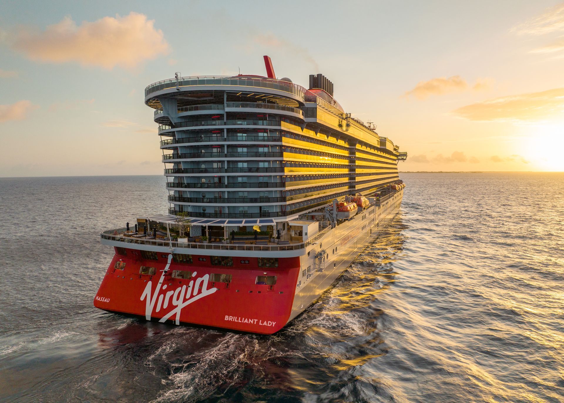 A rear view of the Brilliant Lady by Virgin Voyages as she sails into the sunset