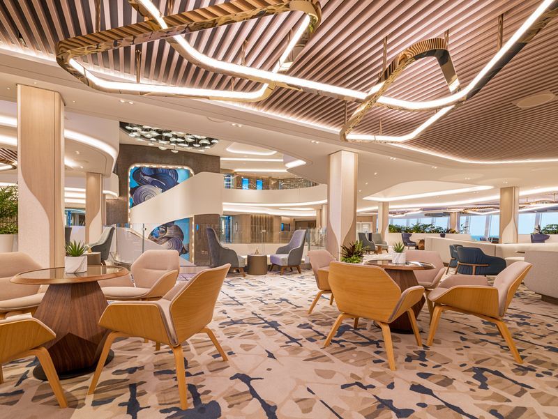 Elegant cruise ship lounge with seating areas, modern decor, and ornate lighting.