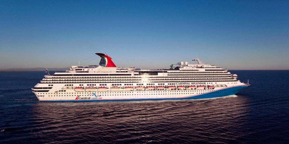 Cruise ship sailing on a blue ocean with a clear sky.