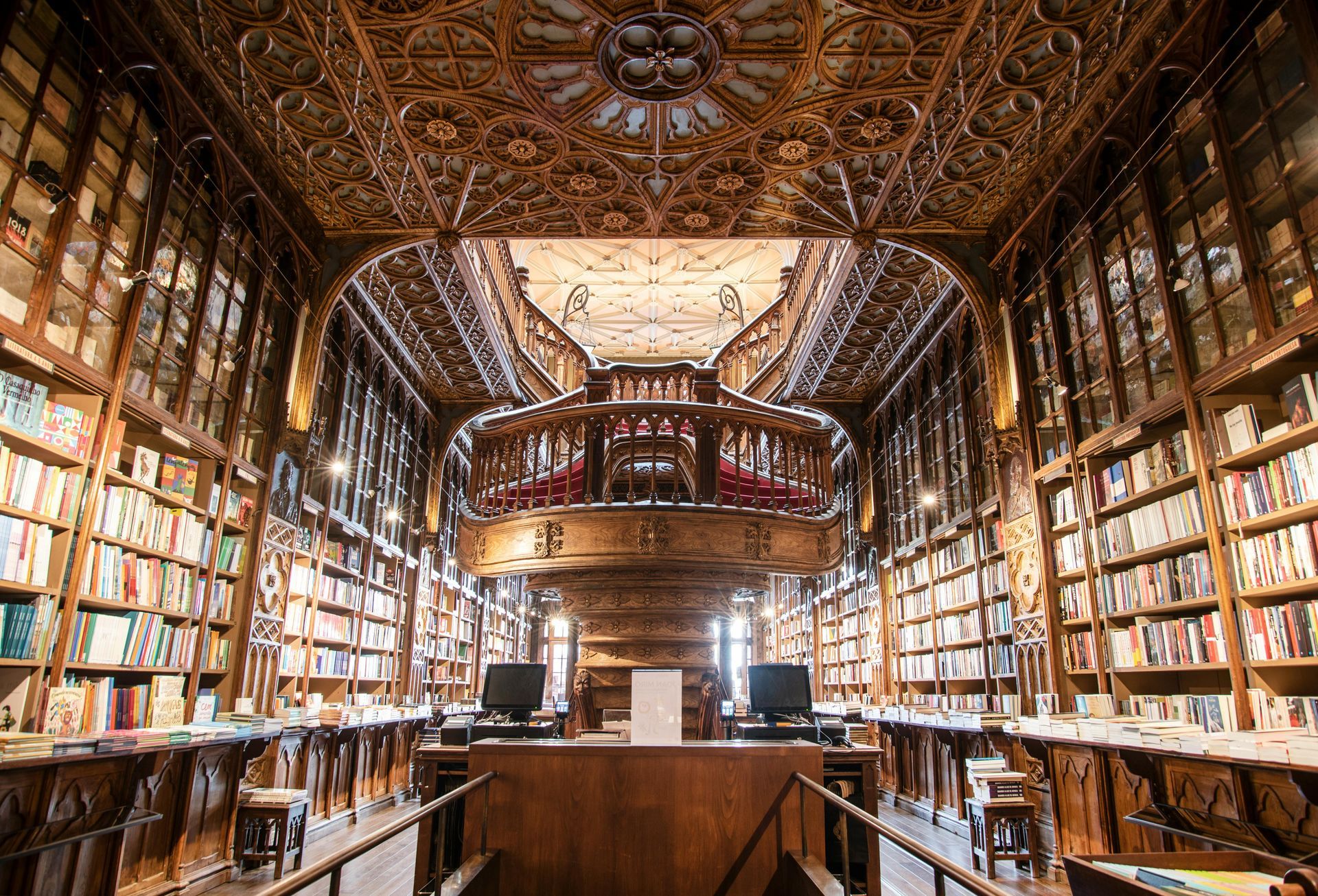 Inside the Livraria Lello bookstore: wooden interior with books on shelves and detailed ceiling.