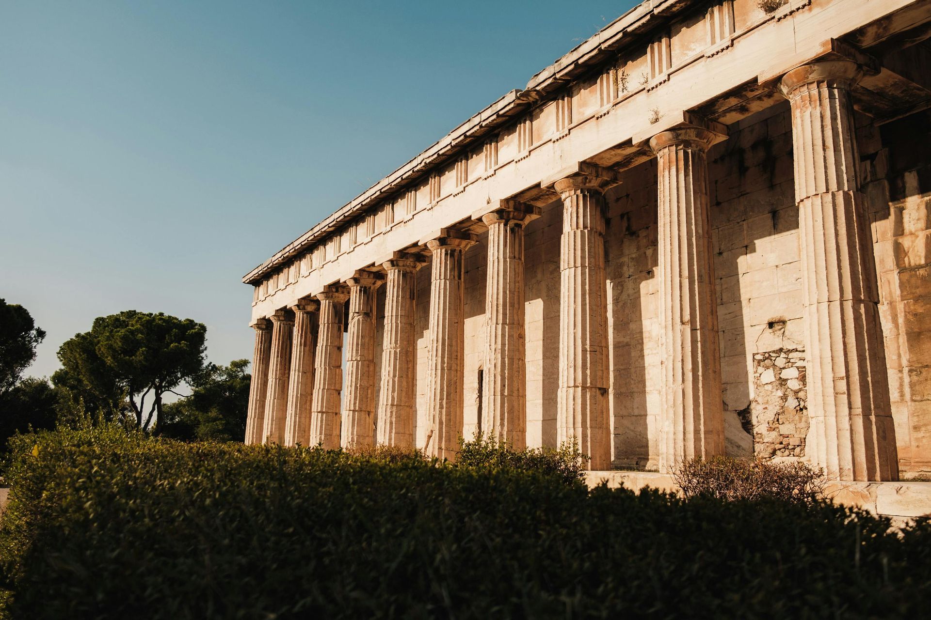 Ancient Greek temple with weathered columns under a clear blue sky.