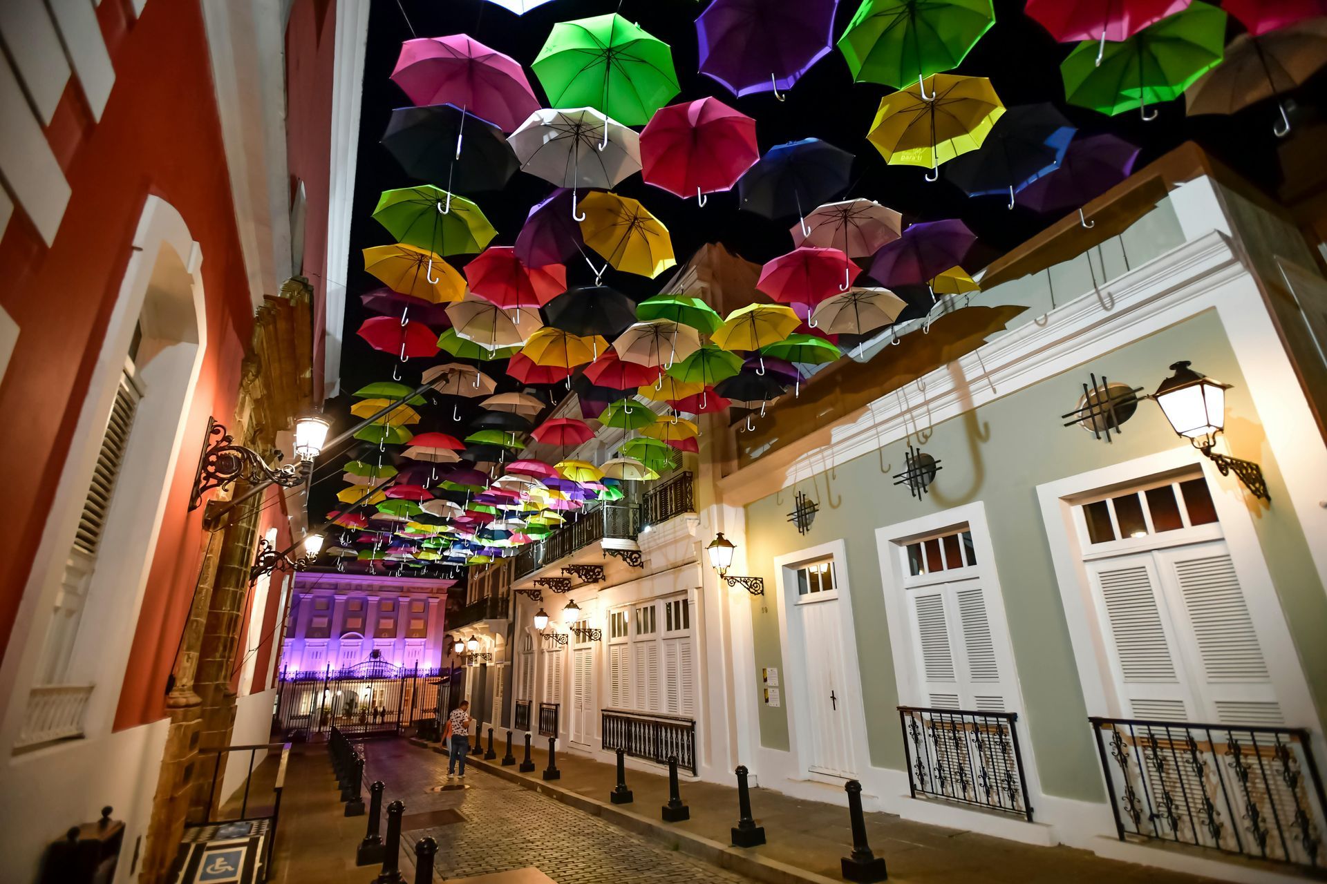 Colorful umbrellas strung over a street in Old San Juan, Puerto Rico, at night.