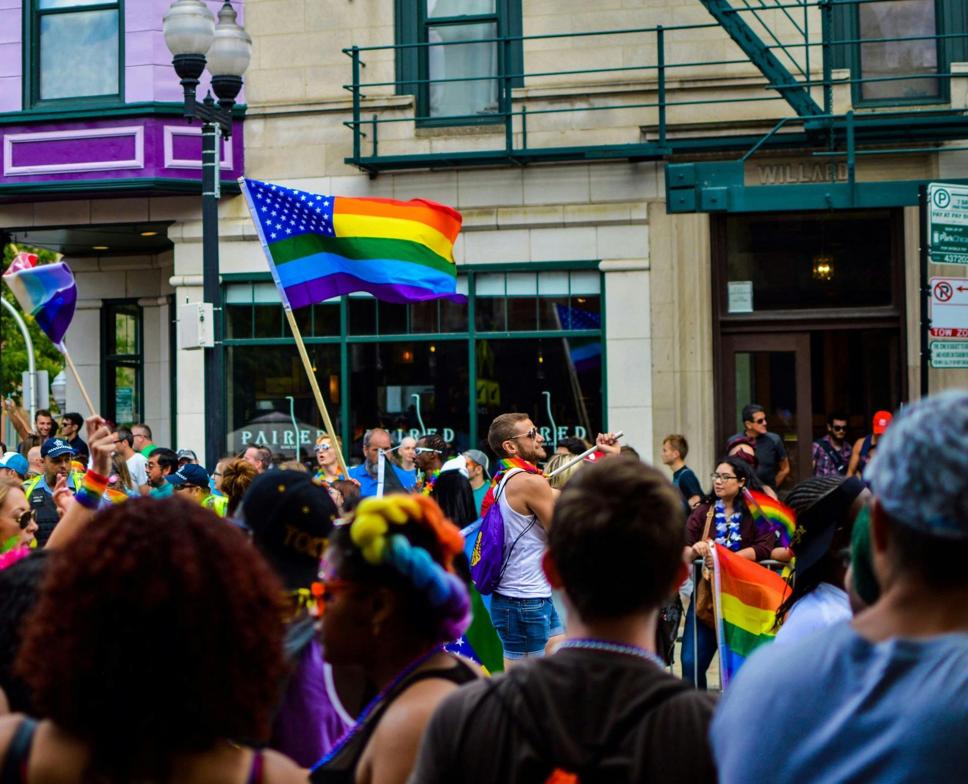 Image of a pride festival with attendees lining a street.