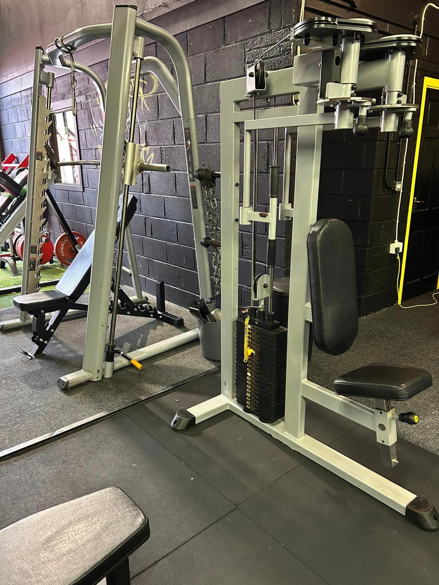 a gym with a lot of exercise equipment and a bench .