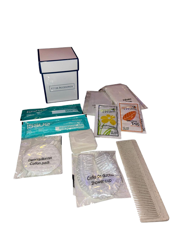 Artículos de aseo del hotel dispersos: una caja, jabones, champús, peine, gorros de ducha y un cepillo de dientes.