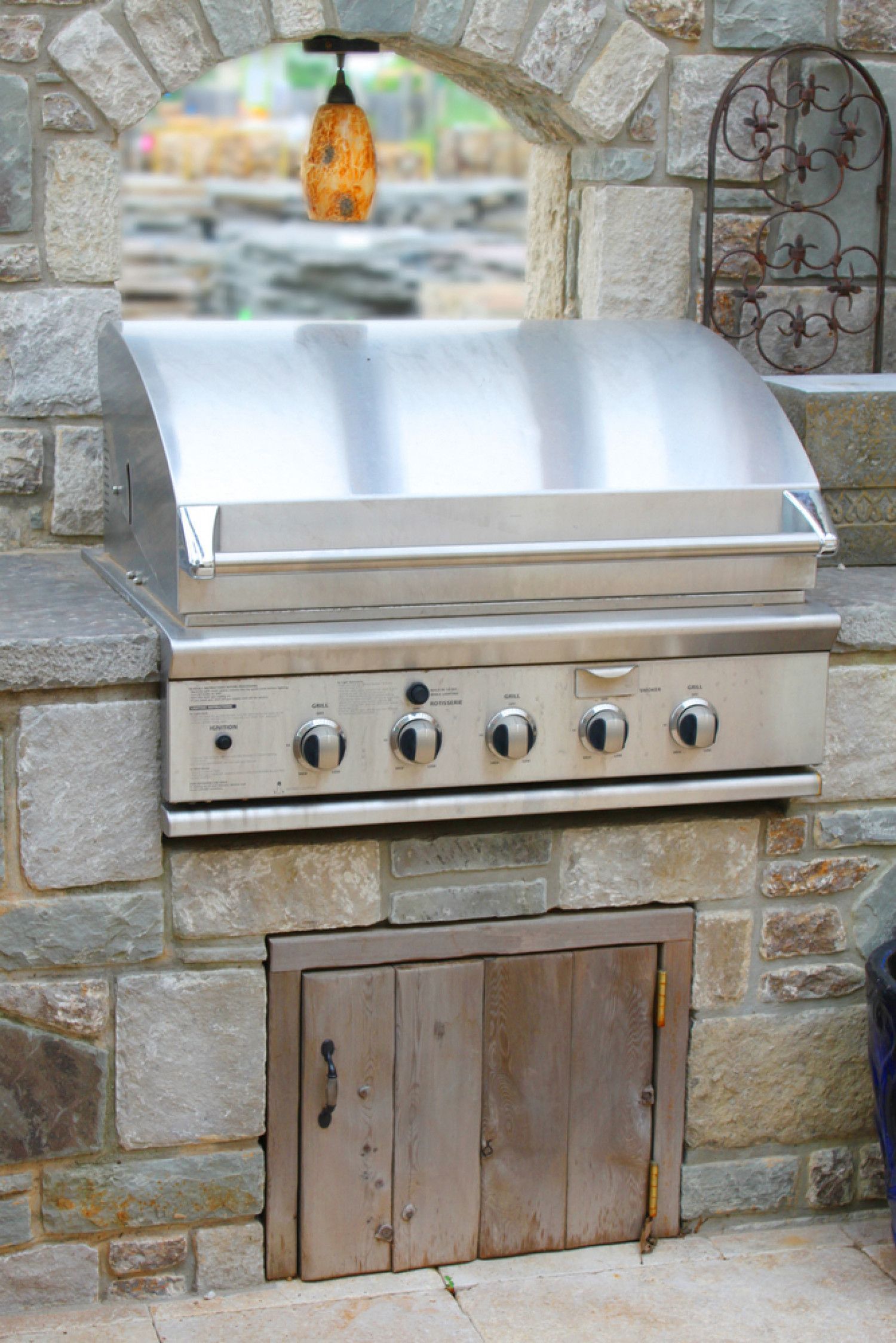 a stainless steel grill is built into a stone wall