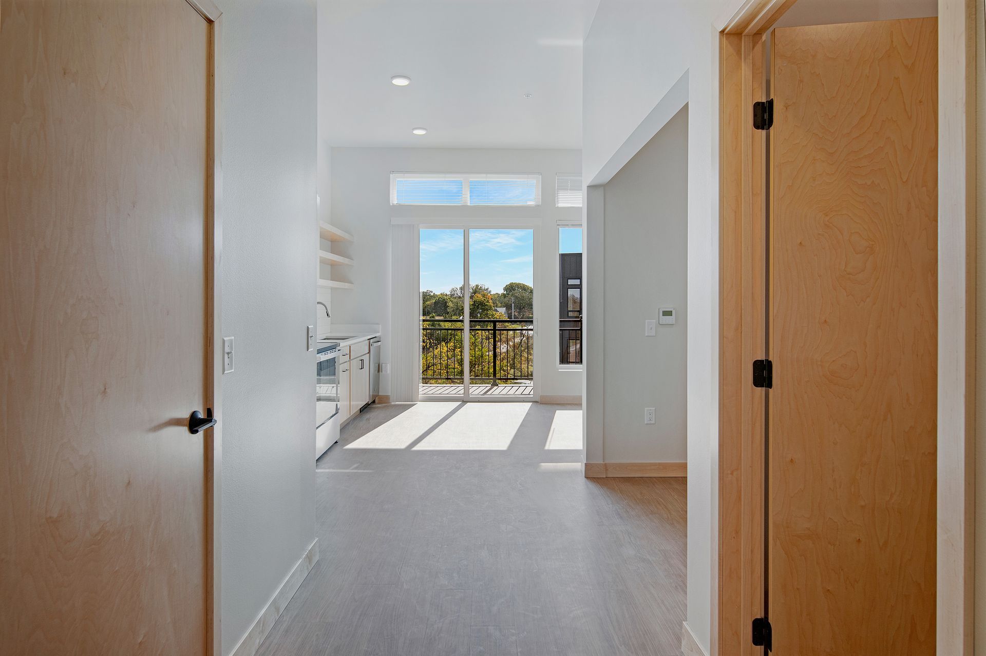 A hallway in a house with a sliding glass door and a balcony.