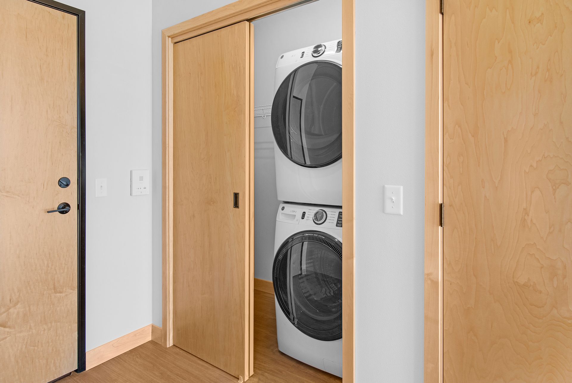 A washer and dryer are stacked on top of each other in a laundry room.