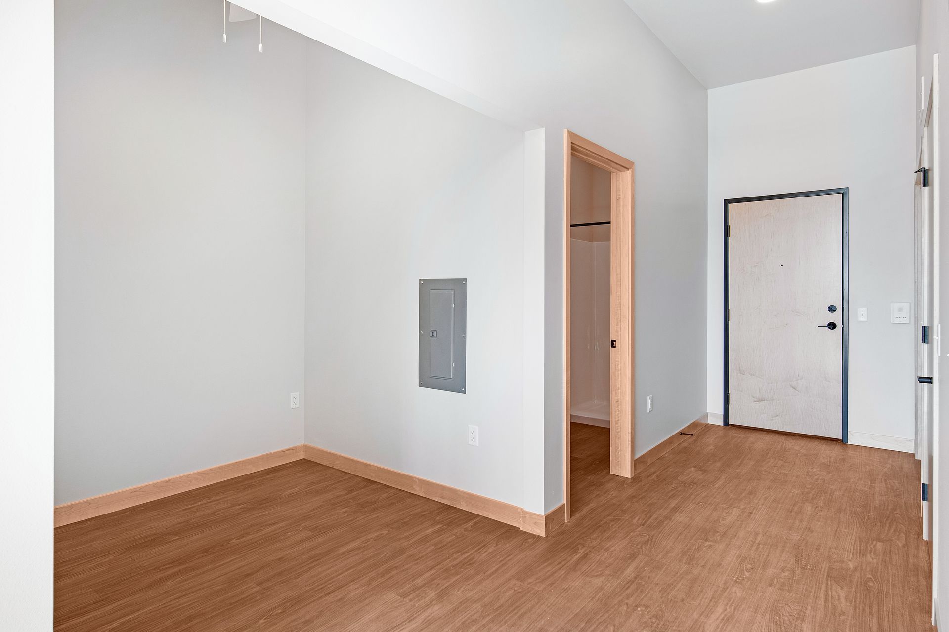 An empty room with hardwood floors and white walls.