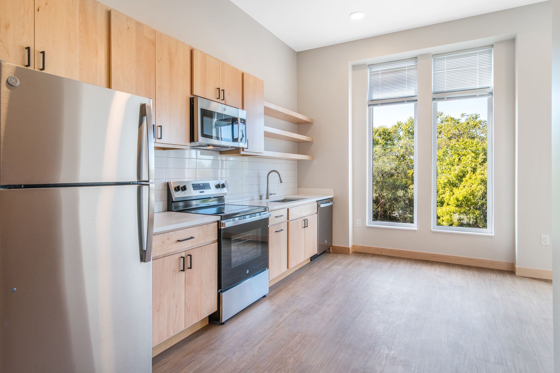 A kitchen with stainless steel appliances and wooden cabinets.