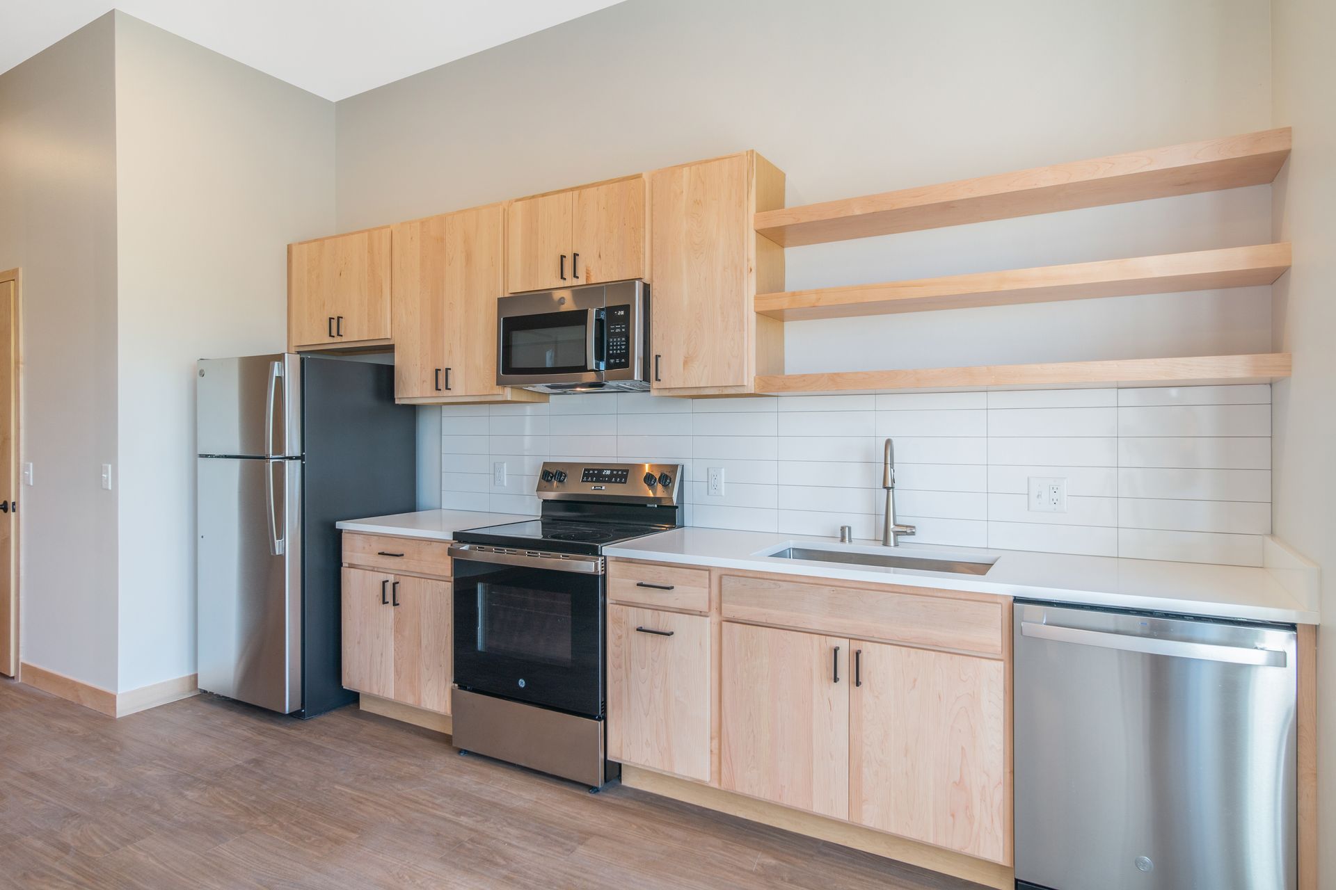 A kitchen with stainless steel appliances and wooden cabinets