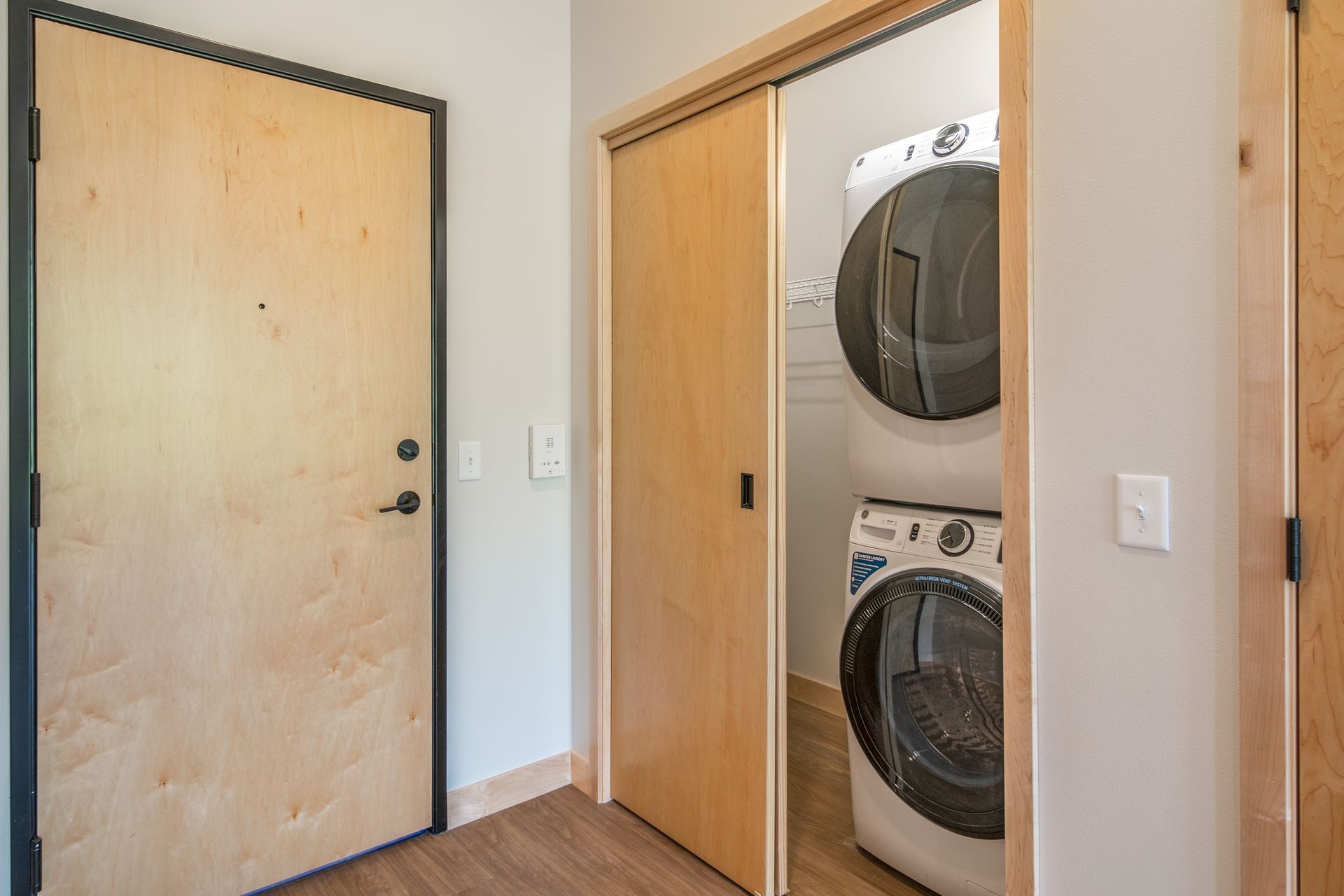 A washer and dryer are stacked on top of each other in a laundry room.