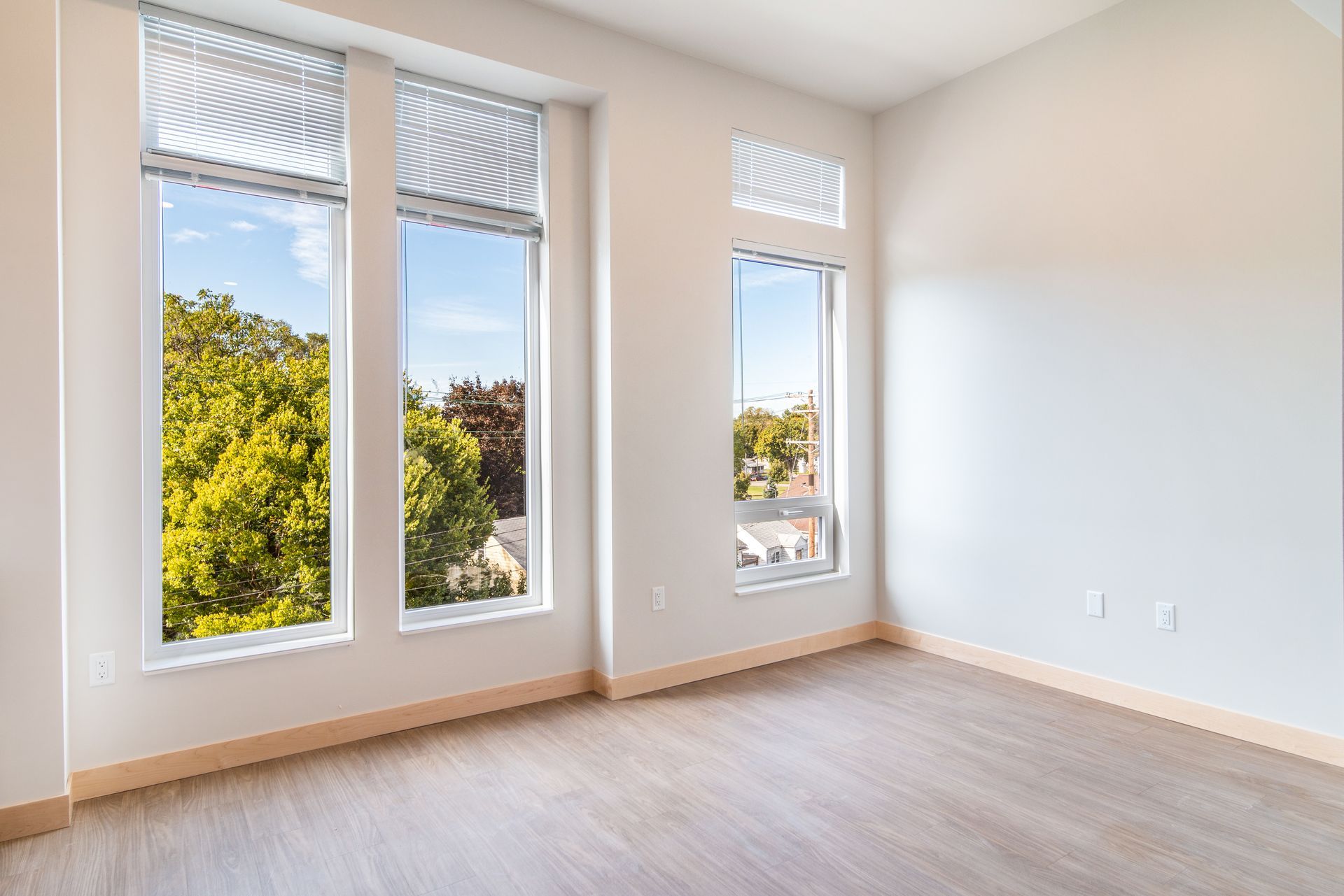 An empty room with a lot of windows and a wooden floor.