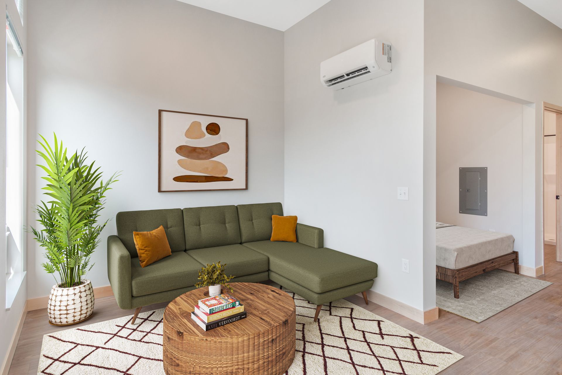 A living room with a green sectional couch and a wicker coffee table.
