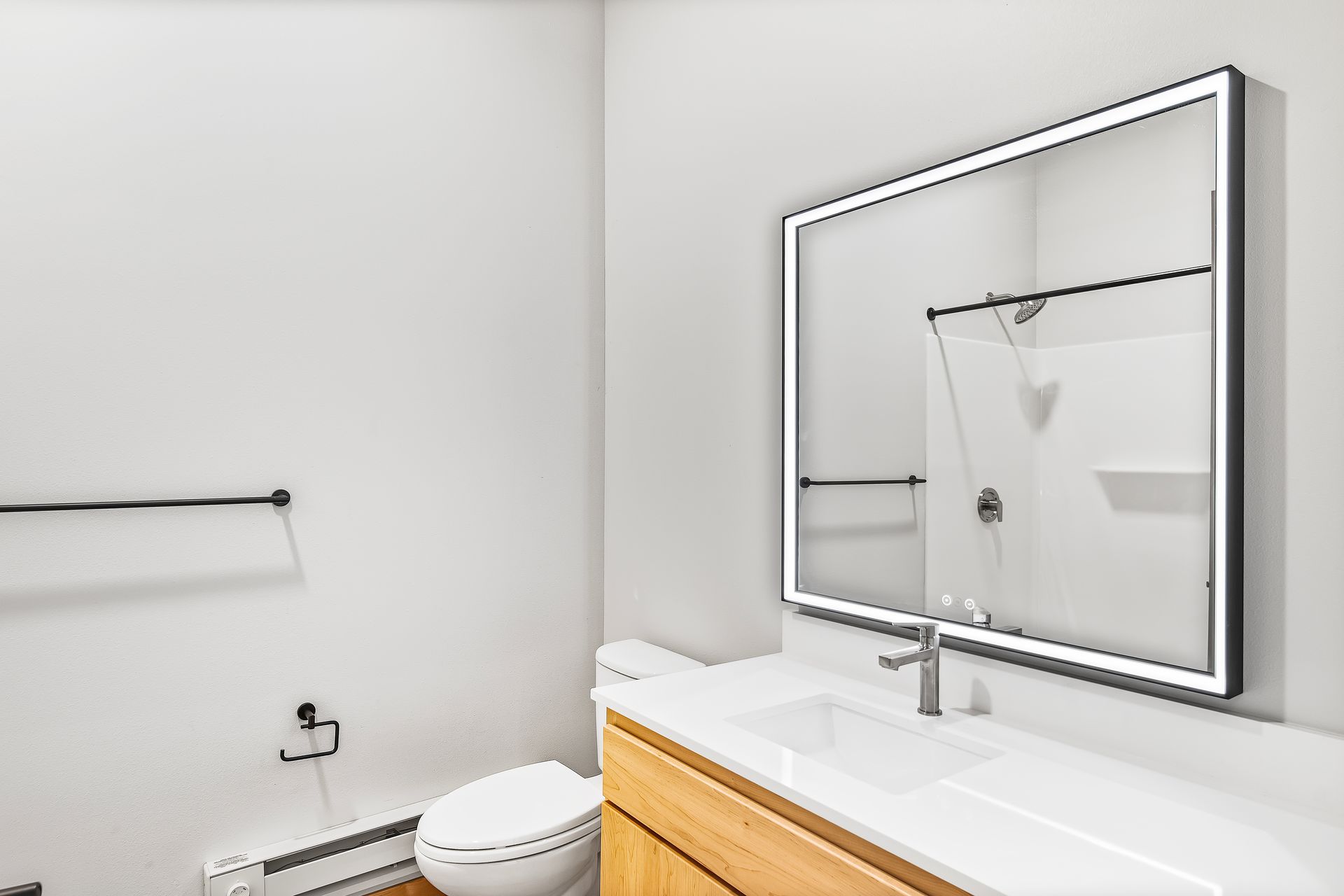 A bathroom with a toilet , sink , and mirror.