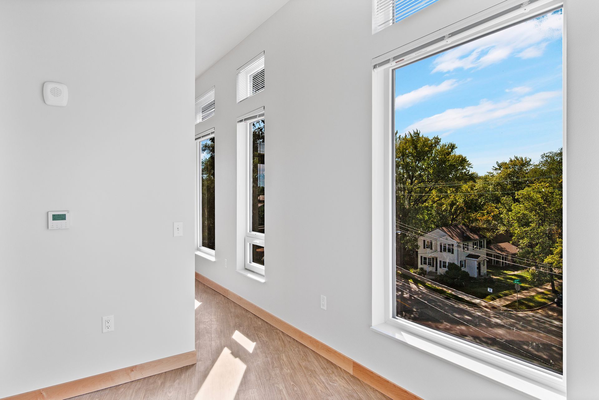 A room with a lot of windows and a view of a house.