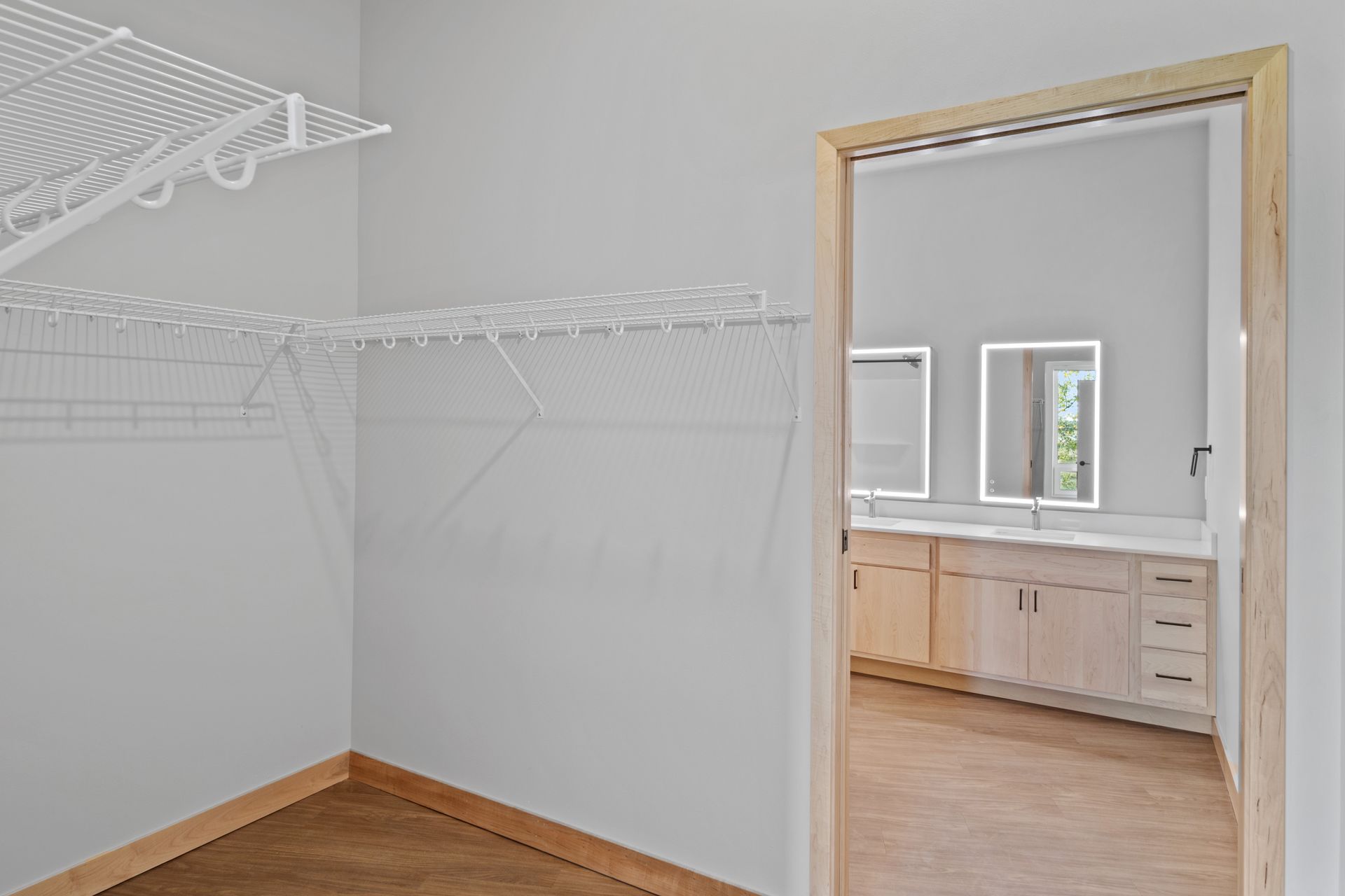 A walk in closet with a sliding door leading to a bathroom.