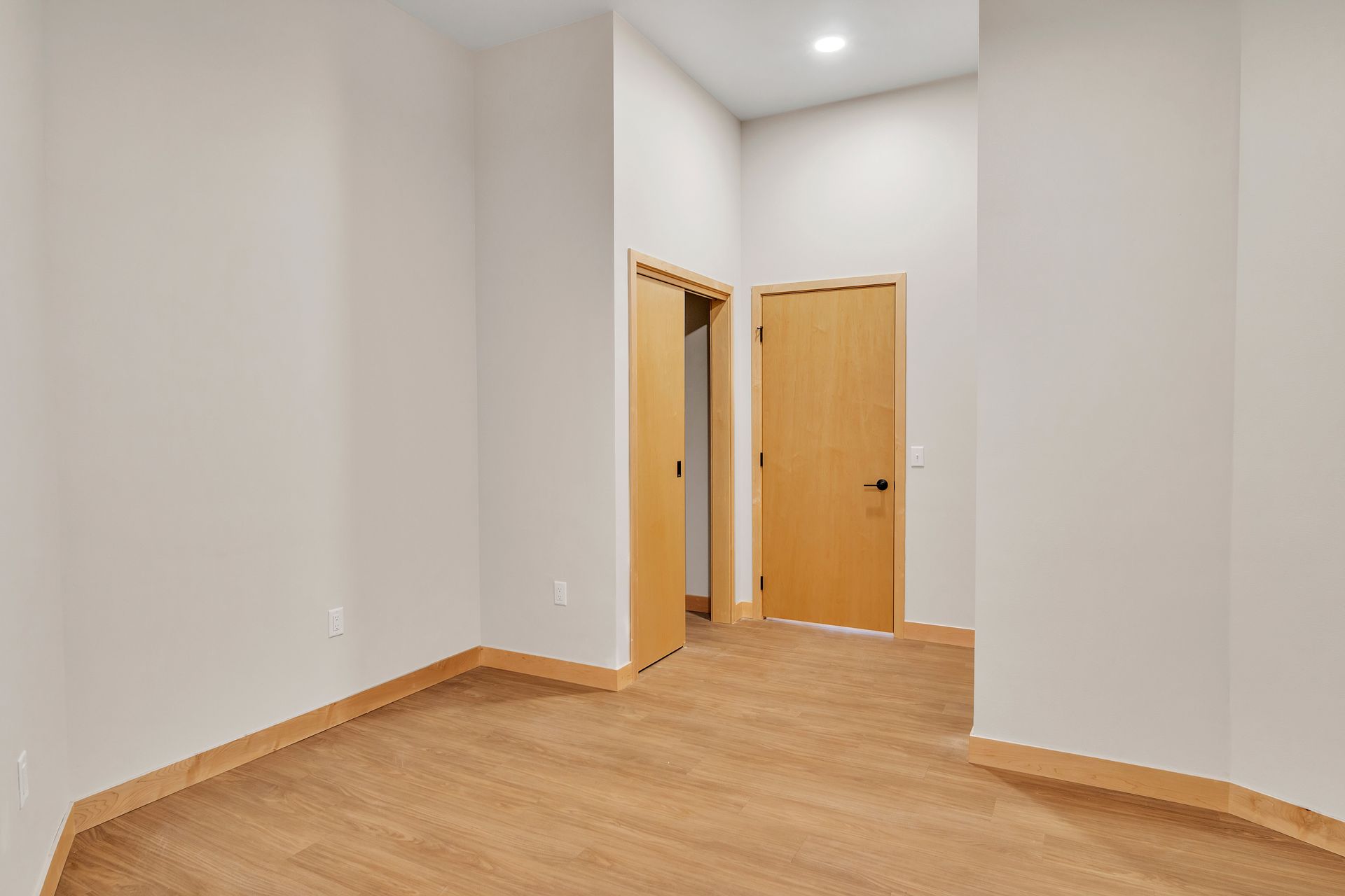 An empty room with wooden floors and a door.