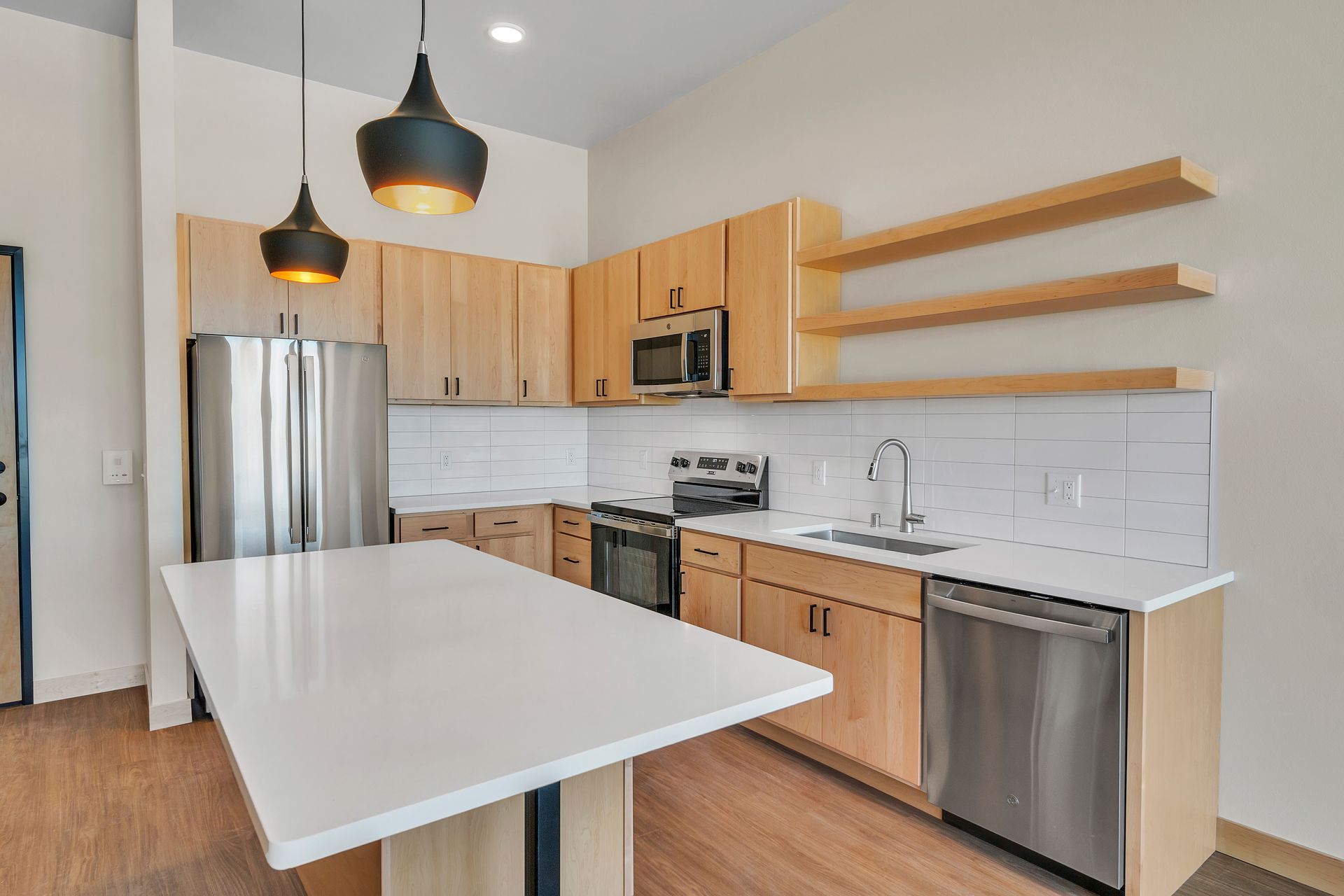 A kitchen with stainless steel appliances and wooden cabinets.