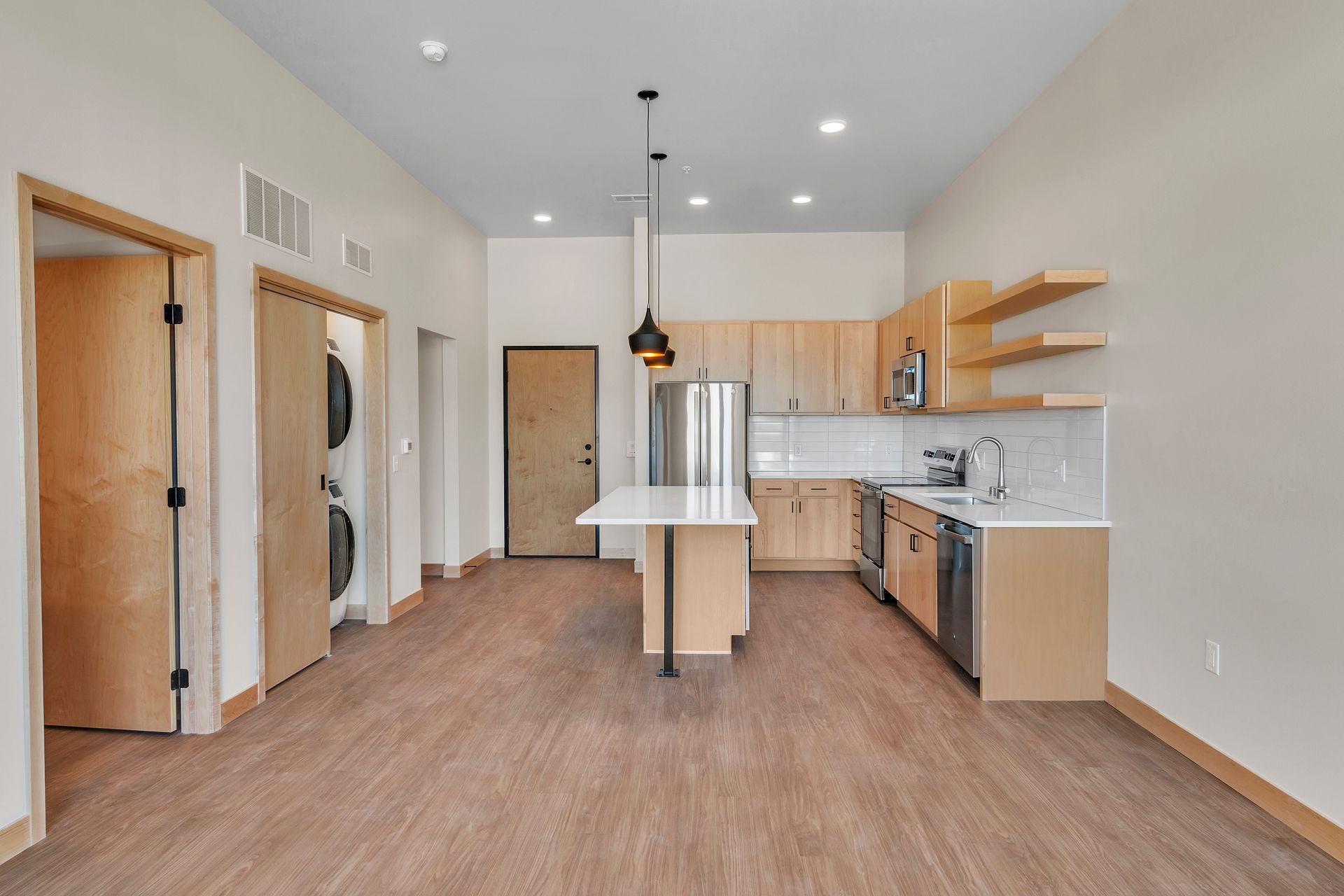A kitchen with wooden cabinets , stainless steel appliances , and a large island.