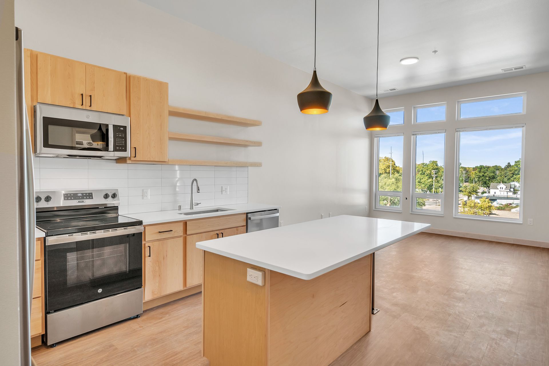 A kitchen with a large island and stainless steel appliances.