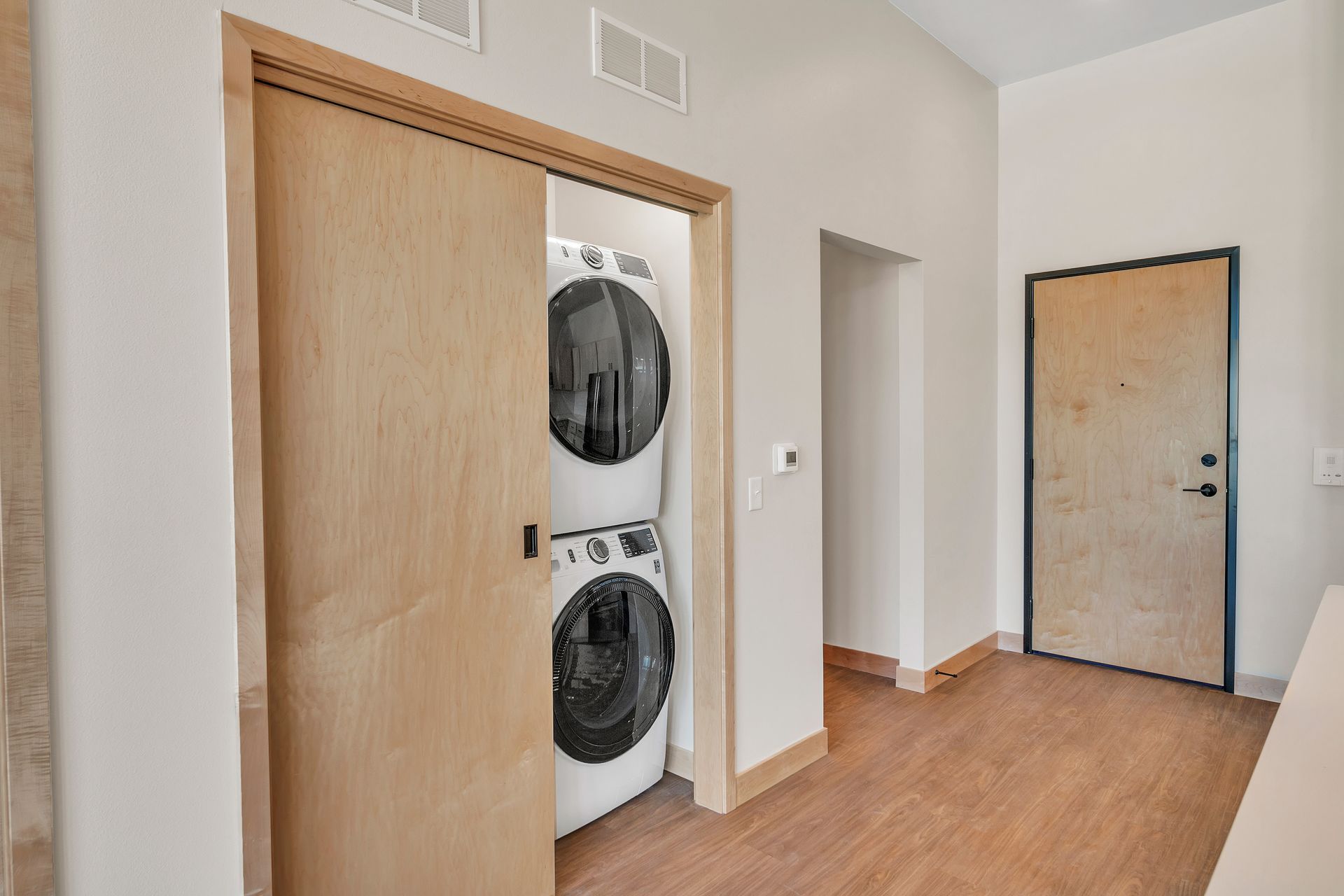 A washer and dryer are stacked on top of each other in a closet.