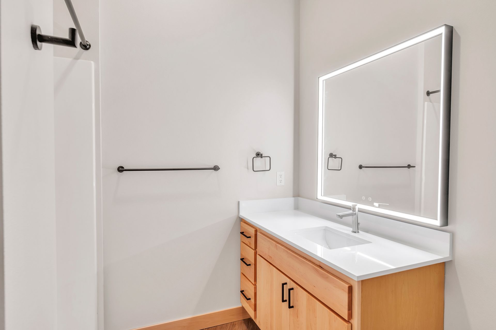 A bathroom with a sink , mirror and shower.