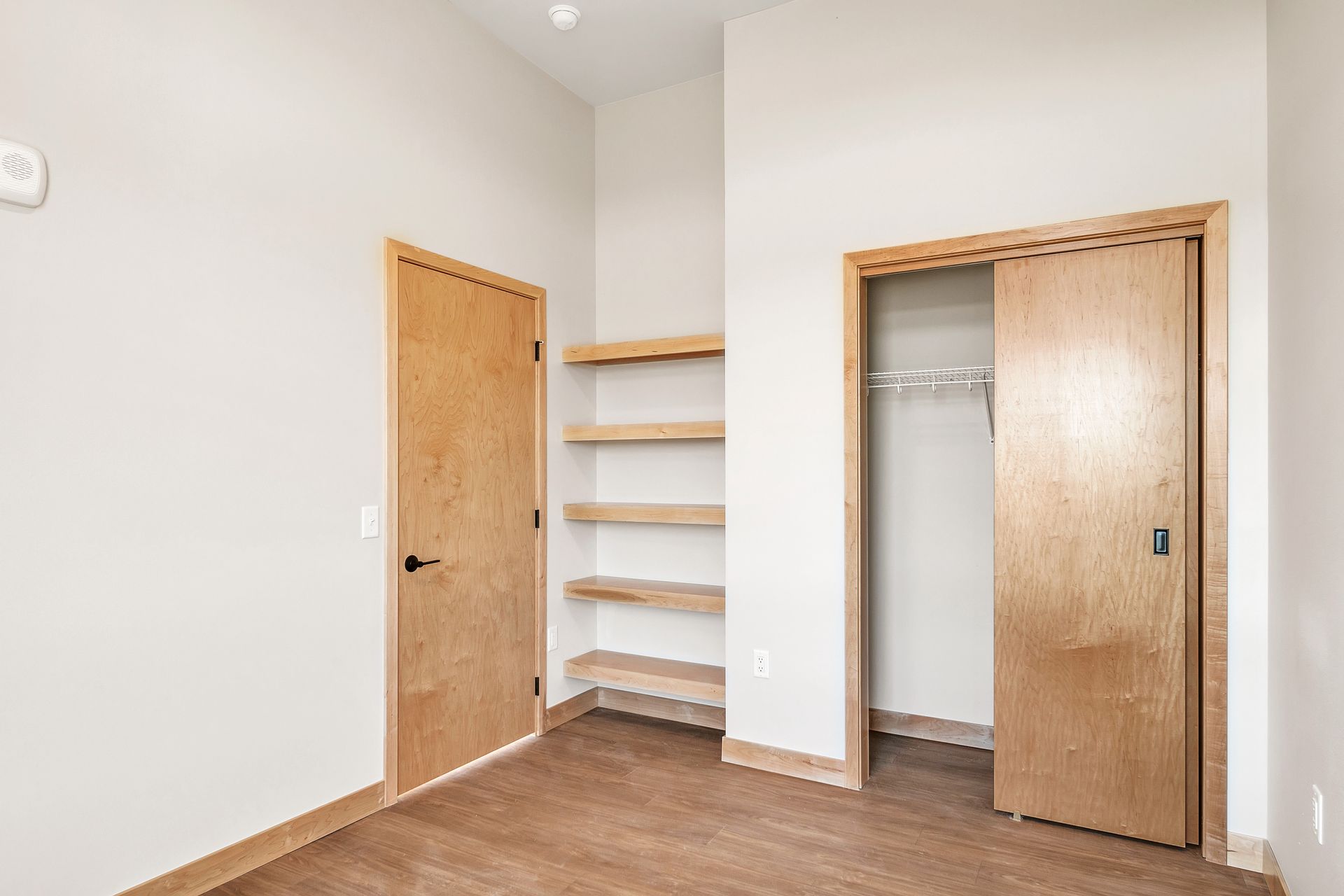 A bedroom with a closet and shelves in it.